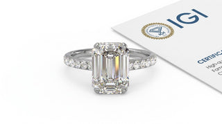 Bague de fiançailles Origine Paris en or blanc 18 carats, diamant de synthèse taille émeraude sur anneau pavé, devant son rapport IGI